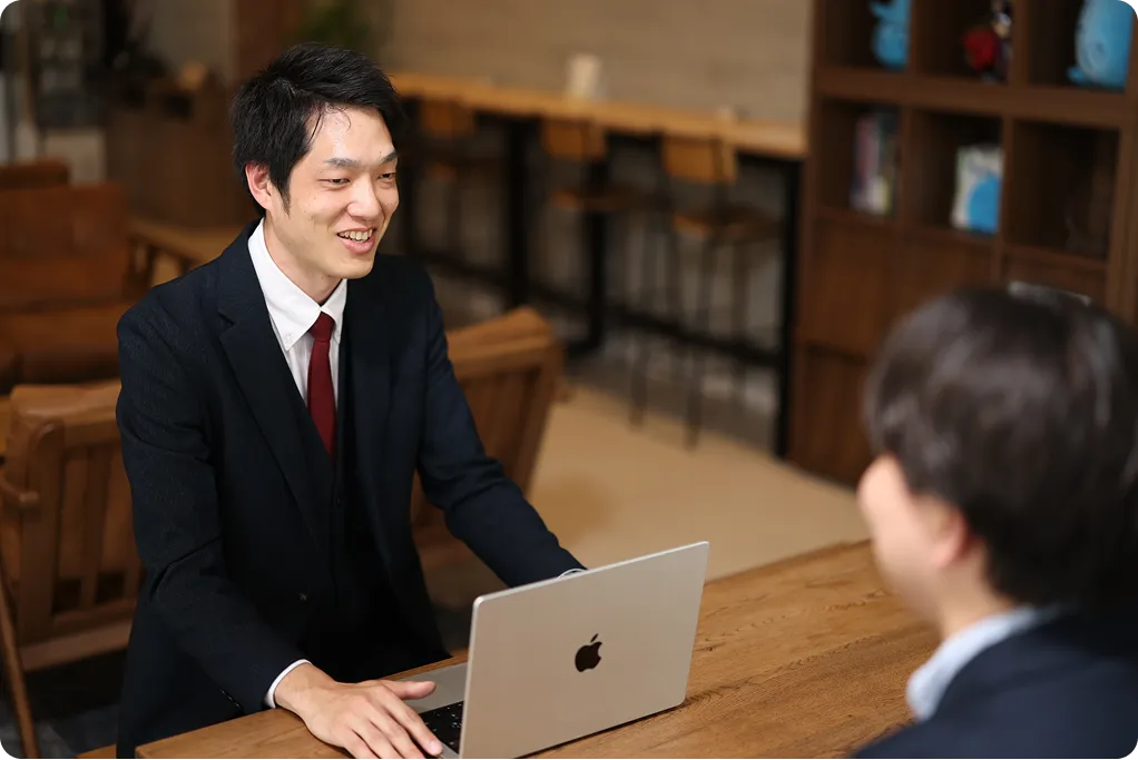 ノートPCを前に商談を行うビジネスパーソン